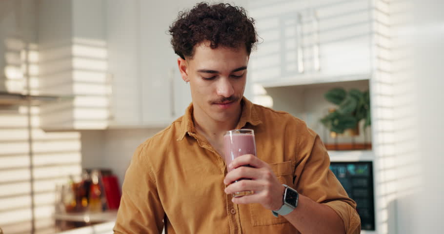 Happy man, smoothie and drink with diet for nutrition, healthy beverage or vitamins in kitchen at home. Male person, weight loss or glass with smile for organic liquid, fruit blend or taste at house