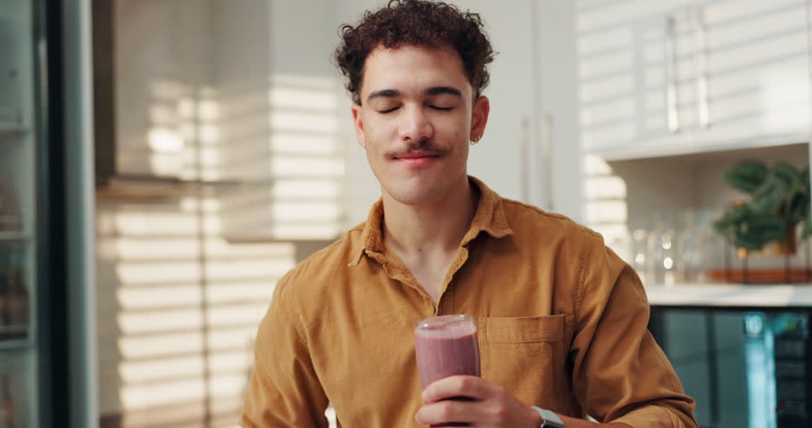 Happy man, smoothie and drink with diet for nutrition, healthy beverage or vitamins in kitchen at home. Male person, weight loss or glass with smile for organic liquid, fruit blend or taste at house