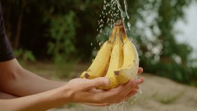 Teenage boy hands holding bananas under running water, washing fruit carefully. Youthful hands rinsing yellow bananas under clear water, cleaning them thoroughly. Adolescent hands grasping ripe - Powered by Shutterstock - Get 15% off with code: PIKWIZARD15