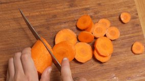 Girl Chopping Carrots on a Wooden Cutting Board, helping mother prepare food - Powered by Shutterstock - Get 15% off with code: PIKWIZARD15