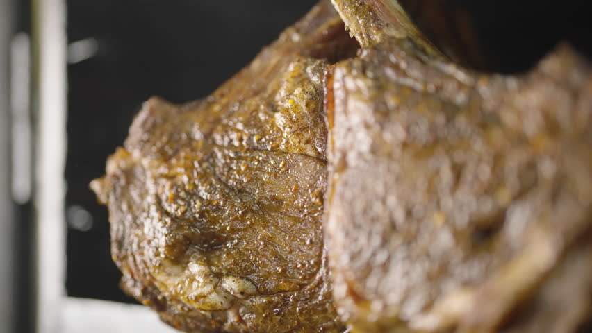 High definition close-up footage of a succulent grilled steak, showcasing its juicy texture and appealing sear.