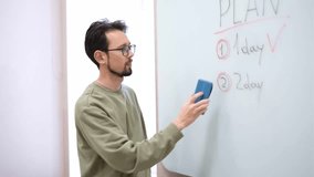 male brunette teacher wipes the board - Powered by Shutterstock - Get 15% off with code: PIKWIZARD15