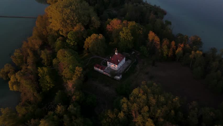 Aerial view Mausinsel, Mouse Island in Woerthsee, Bavaria, Germany. Features Castle Woerth and St. Simpert Chapel, surrounded by water and nature during peaceful sunset scene. Luftbildansicht Worthsee