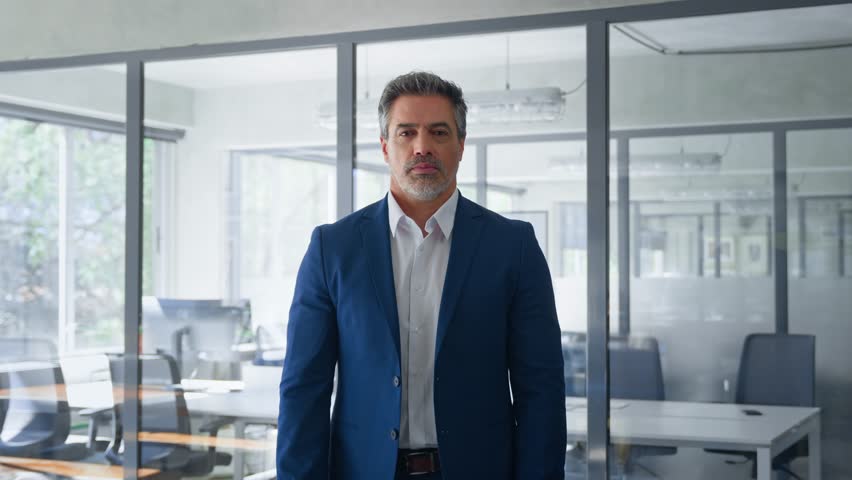 Portrait of indian or latin hispanic mature middle age boss, leader, ceo male businessman in suit in office workplace. Executive confident senior business man specialist looking at camera. Copy space
