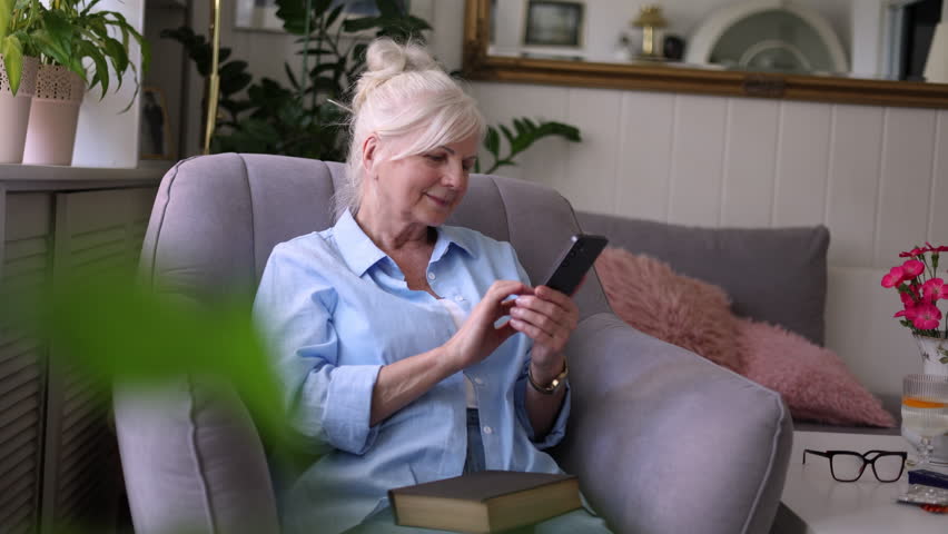 Senior woman using mobile phone at home

