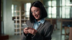 Asian smiling businesswoman office manager architect business woman entrepreneur Korean Chinese Japanese girl satisfied typing message mobile phone user smartphone texting female in building industry - Powered by Shutterstock - Get 15% off with code: PIKWIZARD15