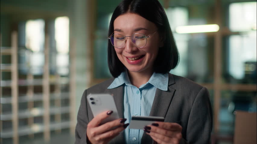 Asian girl Chinese Korean Japanese woman satisfied businesswoman business entrepreneur architect engineer in office online shopping buying internet bank app pay credit card money payment mobile phone