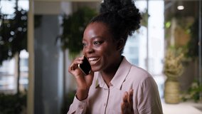 Emotional happy smiling African American ethnic businesswoman girl excited talking mobile phone in office company rejoice yes win cheerful business woman call smartphone indoors conversation good news - Powered by Shutterstock - Get 15% off with code: PIKWIZARD15