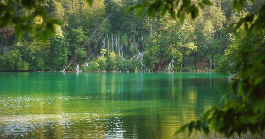 Multiple cascading waterfalls into emerald lake in Plitvice Lakes National Park, Croatia