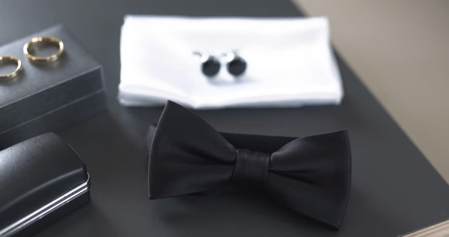 Close-up shot of two gold wedding rings and cufflinks. Ideal for wedding themes, jewelry collections, or fashion.