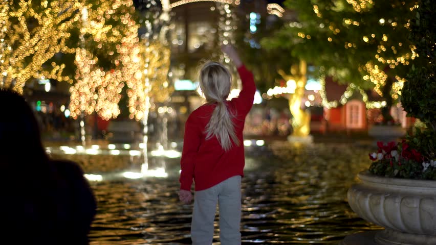 A child by the fountain enjoys a joyful celebration in a festive atmosphere