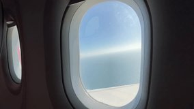 A dramatic view from an airplane window shows the sun shining brightly over a sparkling sea surface. The glare of the light creates a strong visual effect. The airplane wing is faintly visible below - Powered by Shutterstock - Get 15% off with code: PIKWIZARD15