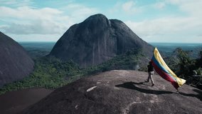 Traveler with Colombian Flag on Top of Cerros de Mavicure - Guainía, Colombia - Powered by Shutterstock - Get 15% off with code: PIKWIZARD15