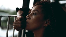 One sad pensive black middle-aged woman gazing at view from balcony in deep melancholic contemplation. Close-up face of an African American lady feeling lost in thought, pondering life's challenges - Powered by Shutterstock - Get 15% off with code: PIKWIZARD15