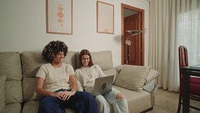 Students sharing laptop on sofa, learning together at home - Powered by Shutterstock - Get 15% off with code: PIKWIZARD15