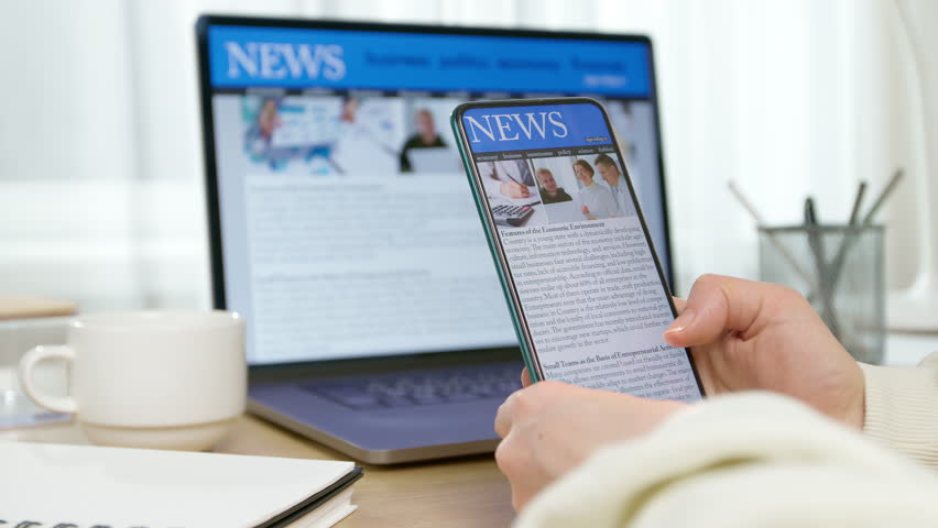 News on the phone and computer screen. Viewing information on the gadget. Press online.
