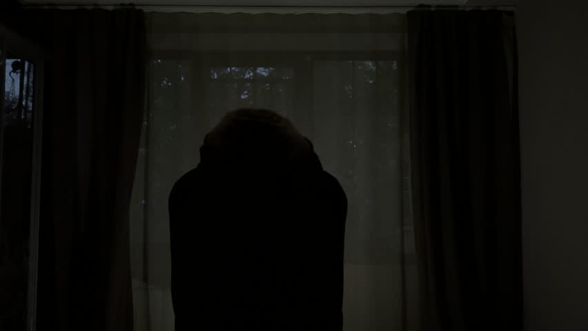 Man alone in a dark room showing signs of anxiety, irritation, and anger.