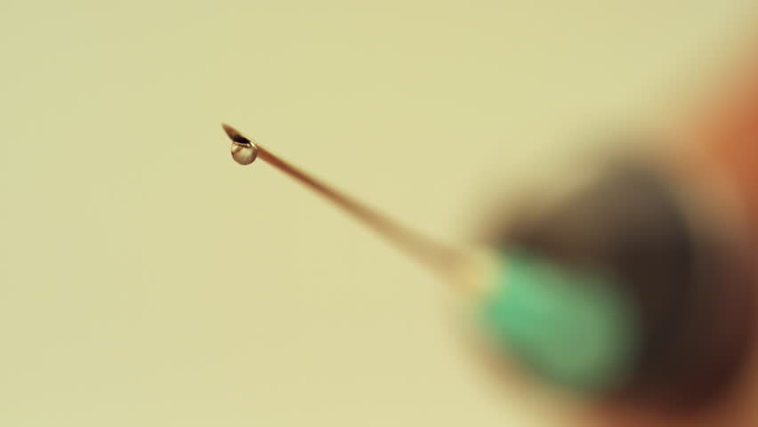 Close-up of a droplet on a syringe needle tip.