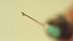 Close-up of a droplet on a syringe needle tip. - Powered by Shutterstock - Get 15% off with code: PIKWIZARD15