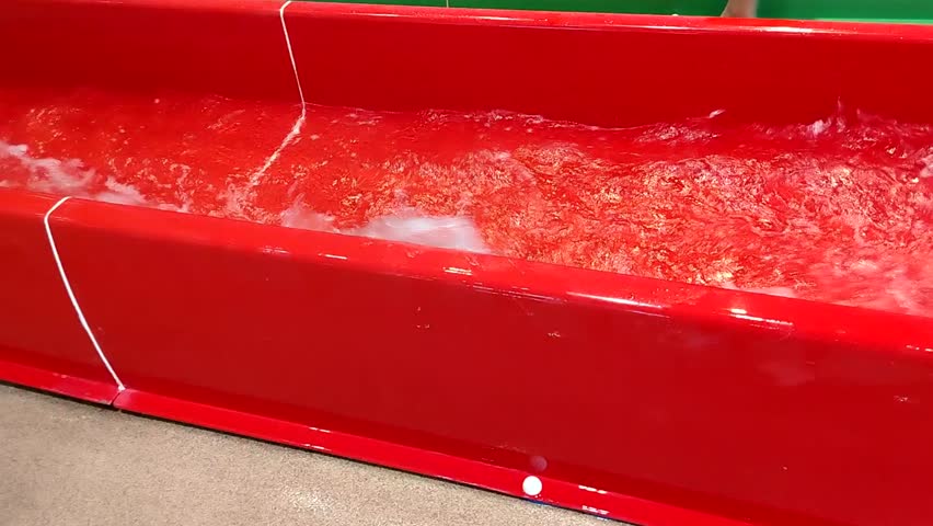 Splashing water in the chute of a brightly colored waterslide, a place to relax and have fun on the water
