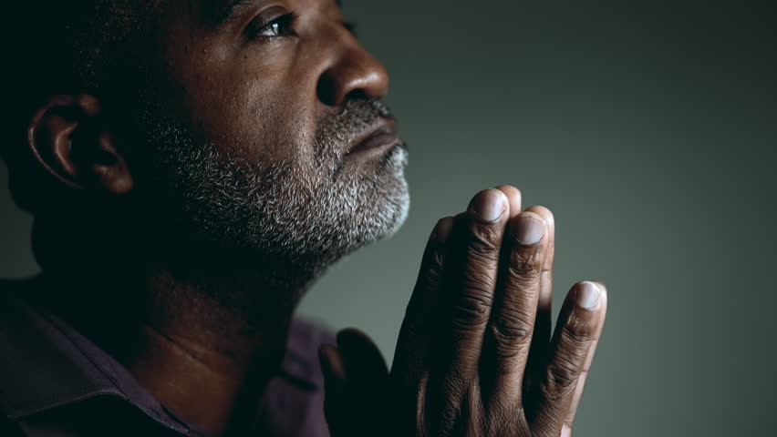 Earnest African American Elder Seeking Divine Guidance in Prayer, Eyes Shut and Hands Together, Senior Man in Deep Contemplation Asking for Help and Support