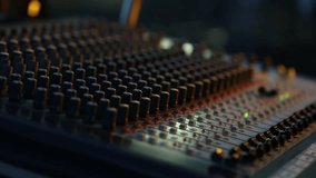 Close-up of sound technician adjusting levels on audio mixing console. Red light, sound check at the nightclub. Modern audio system. - Powered by Shutterstock - Get 15% off with code: PIKWIZARD15