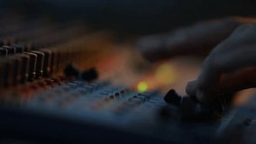 Close-up of sound technician adjusting levels on audio mixing console. Red light, sound check at the nightclub. Modern audio system. - Powered by Shutterstock - Get 15% off with code: PIKWIZARD15