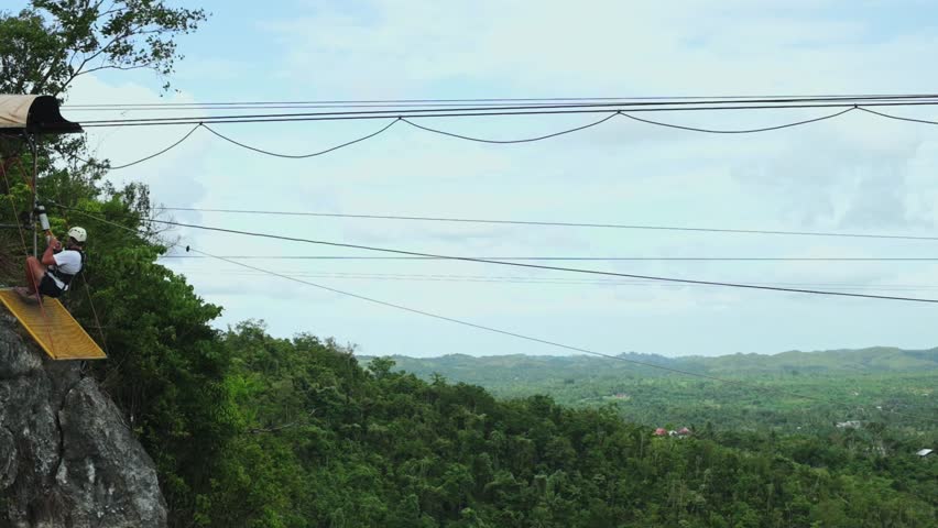 Adventure seeker enjoying zipline ride over lush greenery in Bohol Island Philippines, thrilling experience in adventure park, outdoor fun concept