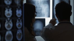 Doctors examining X-ray images in a medical setting. - Powered by Shutterstock - Get 15% off with code: PIKWIZARD15