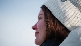 Side view of woman adjusting fancy tinted goggles under clear sky wearing white beanie and warm coat gentle breeze tousles hair sunshine reflects off visor conveying cheerful winter fashion mood - Powered by Shutterstock - Get 15% off with code: PIKWIZARD15