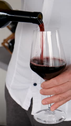 Glass of red wine in hands. Selective focus.