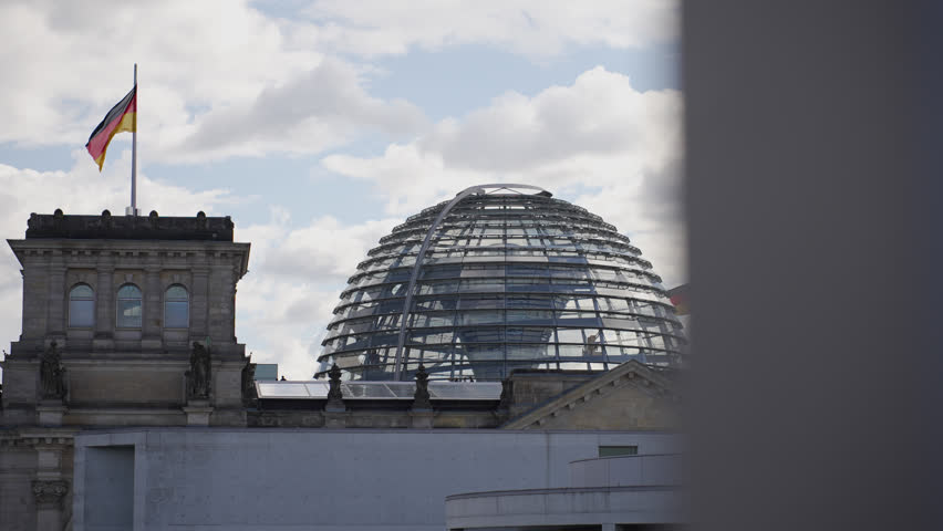 View of the Reichstag dome, Side track shot German Bundestag, Berlin, cloudy sky, German flag