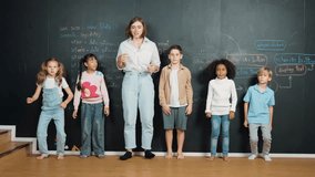 Multicultural happy student and teacher smiling and standing at blackboard with engineering code or prompt written. Kid express feeling of happy and enjoy with studying in STEM classroom. Erudition. - Powered by Shutterstock - Get 15% off with code: PIKWIZARD15