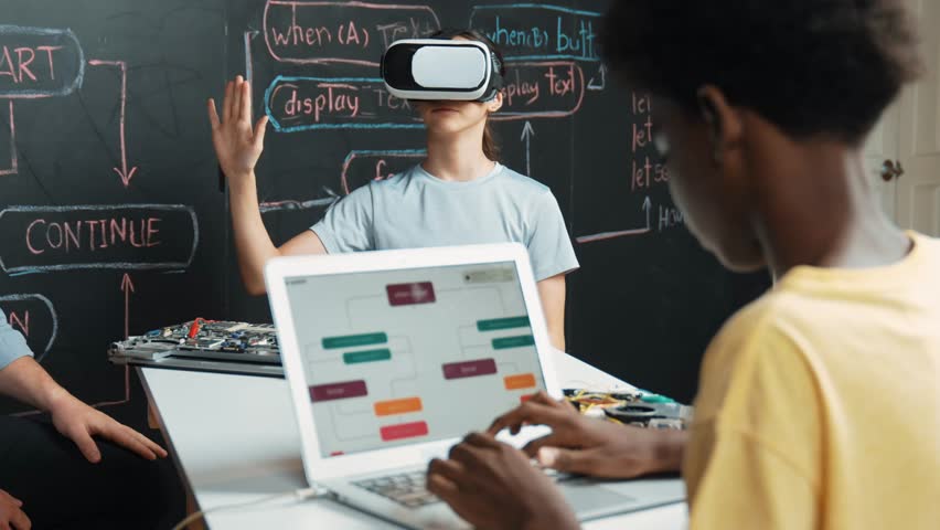 African boy programming system while caucasian girl enter metaverse while sitting at blackboard with engineering code written.high school girl wearing VR or headset in STEM technology. Edification