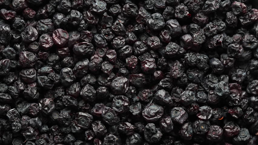 Dried wild blueberries background, rotates, close up, top view, macro. Pile of dry blueberry from dehydrator. Concept of preserving vitamins for winter, healthy eating