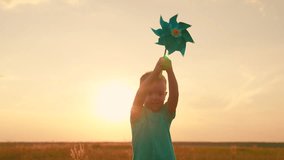 Childhood baby. Child boy runs with toy wind pinwheel in his hand on summer field, sun day. Happy child playing with toy pinwheel outdoors in summer park sky. Family holiday, nature. Baby nature - Powered by Shutterstock - Get 15% off with code: PIKWIZARD15