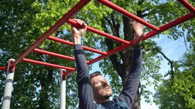 Male athlete training on red monkey bars in outdoor gym. Man doing sport exercises in open air park for wellness and body control. Concept of fitness, endurance and healthy lifestyle - Powered by Shutterstock - Get 15% off with code: PIKWIZARD15