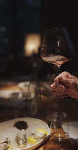Champagne tasting, Wine glasses are on the table, stylish table setting, A man's hand holds a beautiful elegant glass with rose sparkling wine, an intimate light, a plate with oysters and lemon