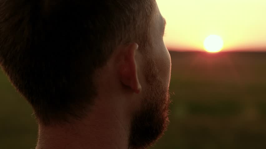 Man enjoying beautiful nature. Man thoughtfully looks at sunset sky. Portrait, man face closeup, nature. Happy man praying outdoor, sunrise, religion. Human travel. Hiker looking into distance at dawn