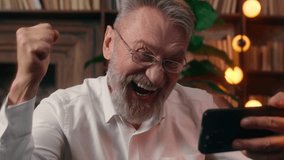 Happy old Caucasian man holding using mobile phone smartphone male businessman online game winning bet emotional business office success indoor mature senior worried winner achieve casino win victory - Powered by Shutterstock - Get 15% off with code: PIKWIZARD15