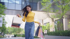 Asian young beautiful woman shopping goods outdoor in department store. Attractive female holding shopping bags then walking alone with happiness, enjoy purchasing in shopping mall marketplace center. - Powered by Shutterstock - Get 15% off with code: PIKWIZARD15