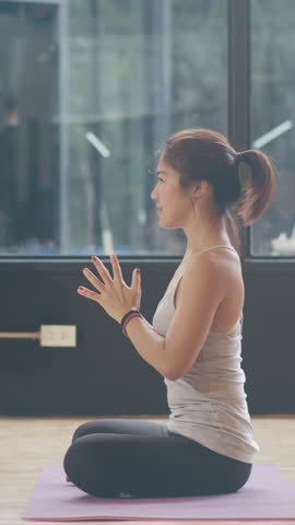 Vertical Screen : Young Asian sporty attractive people practicing yoga lesson with instructor. Asia group of women exercising healthy lifestyle in fitness studio. Sport activity ballet dancing class.