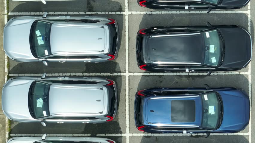 The view reveals perfectly aligned vehicles in a well-maintained lot, reflecting the precision and orderliness necessary in the automotive industry for effective fleet management.
