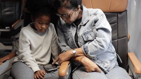 Passenger : African American sister and little girl traveling by an airplane. serving drinks.  Female steward serving glass of water for passengers on board. Flight attendant  and Cart on airplane - Powered by Shutterstock - Get 15% off with code: PIKWIZARD15