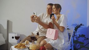 A young couple is talking to friends on a c using a phone while celebrating Valentine's Day or an anniversary. The girl shows a gift from her boyfriend and is happy about the gift. - Powered by Shutterstock - Get 15% off with code: PIKWIZARD15