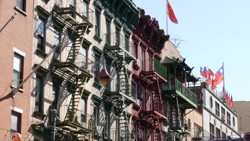New York City, United States. Manhattan Chinatown Mott street, chinese ethnic district buildings architecture, USA. Flags on chinese community center, little China. Fire escape ladder. Attached houses