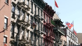 New York City, United States. Manhattan Chinatown Mott street, chinese ethnic district buildings architecture, USA. Flags on chinese community center, little China. Fire escape ladder. Attached houses - Powered by Shutterstock - Get 15% off with code: PIKWIZARD15