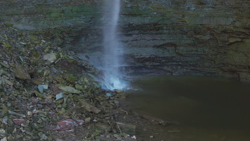 Waterfall flowing into a calm pool, surrounded by rocky terrain, Hamilton, Ontario