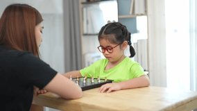 Engaging mother-child chess game indoors, nurturing skills and bonding moments with laughter and concentration in a cozy family environment - Powered by Shutterstock - Get 15% off with code: PIKWIZARD15