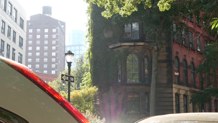 New York City Stuyvesant street corner, intersection one way arrow. Manhattan residential building architecture, United States real estate. Red brick house, green ivy vine plant leaves covered wall.
